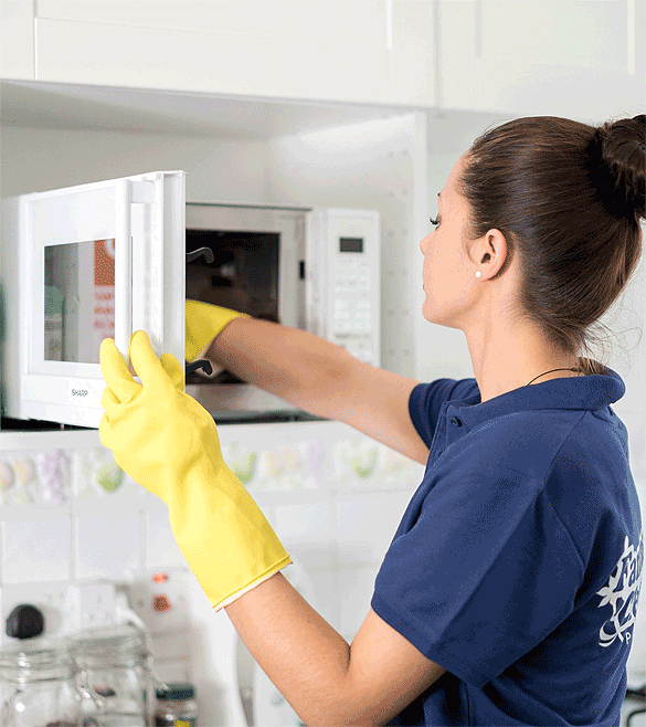 Maid cleaning a microwave