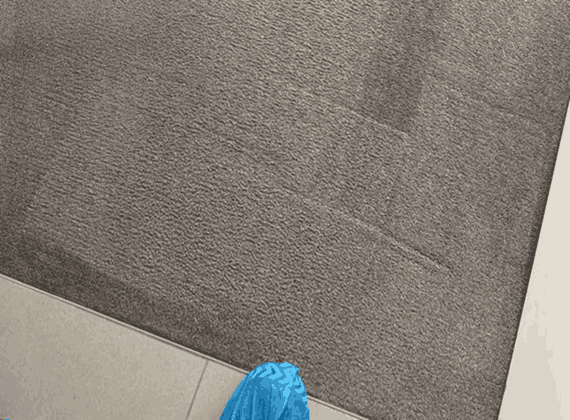 Technician wearing protective overshoes on a just-cleaned carpet in Melbourne