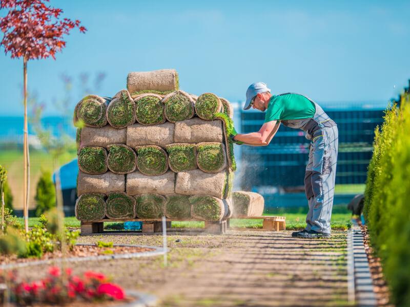 gardener working to pile up cut grass