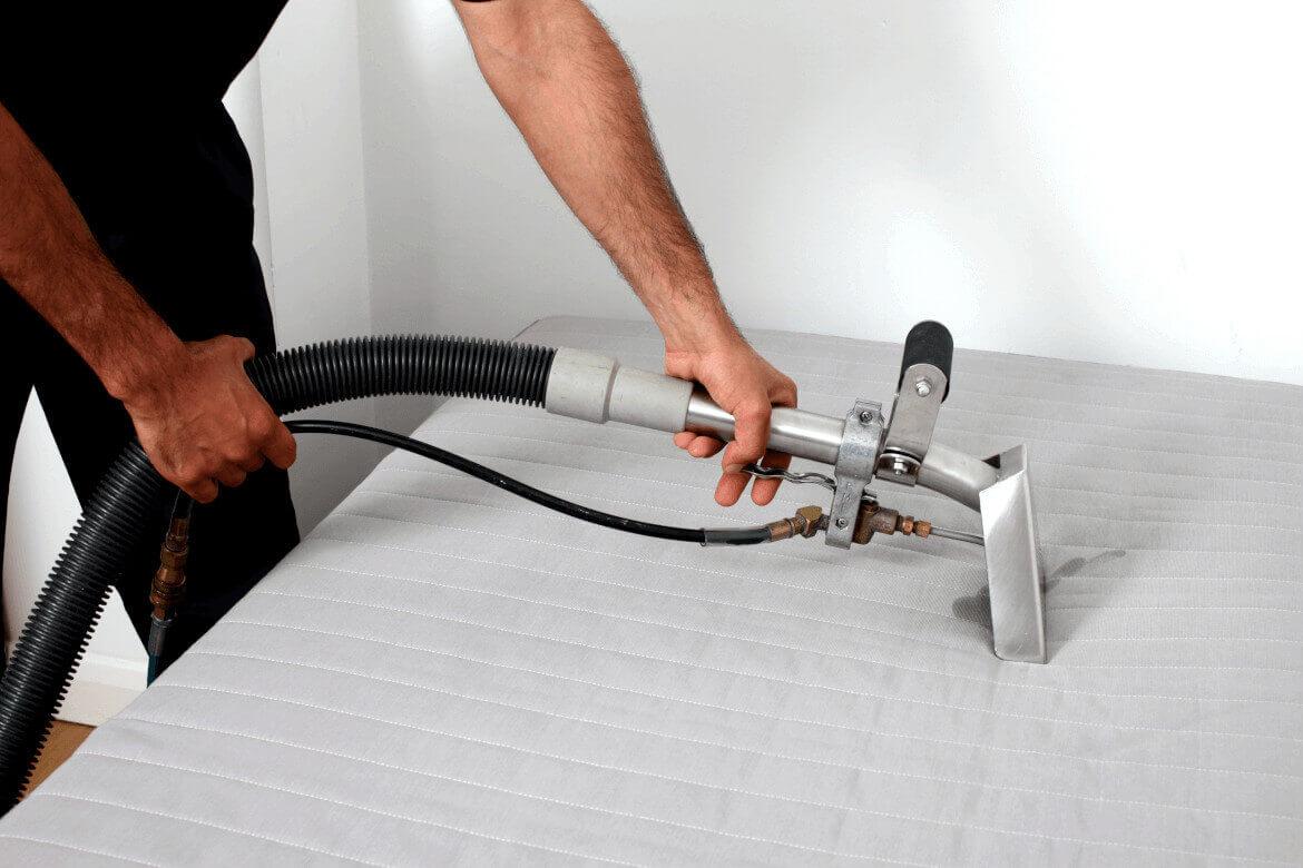 close up of ndis mattress cleaning machine nozzle being pressed firmly down on a mattress to extract contaminants